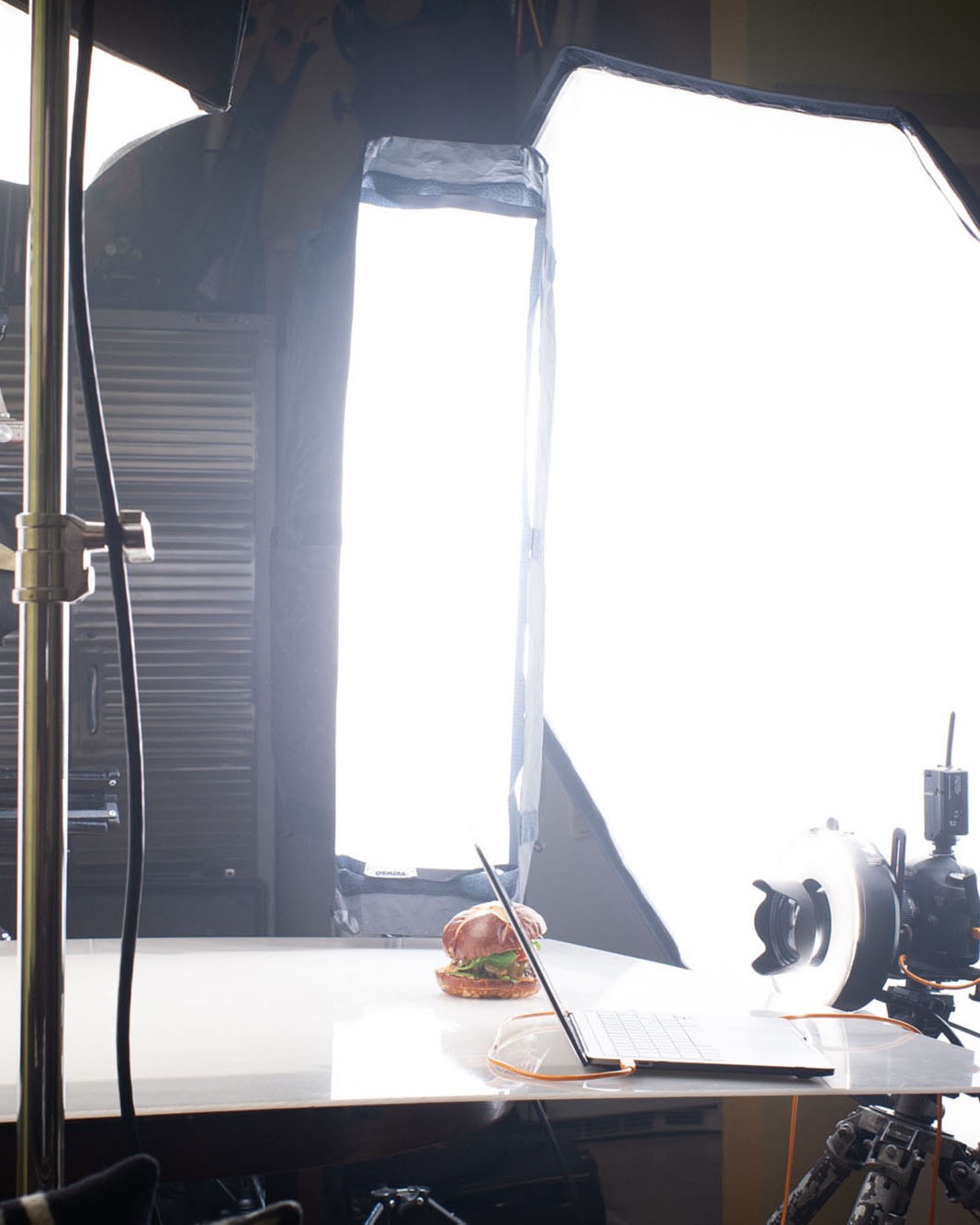A behind the scenes view of a burger being photographed in a photo studio.