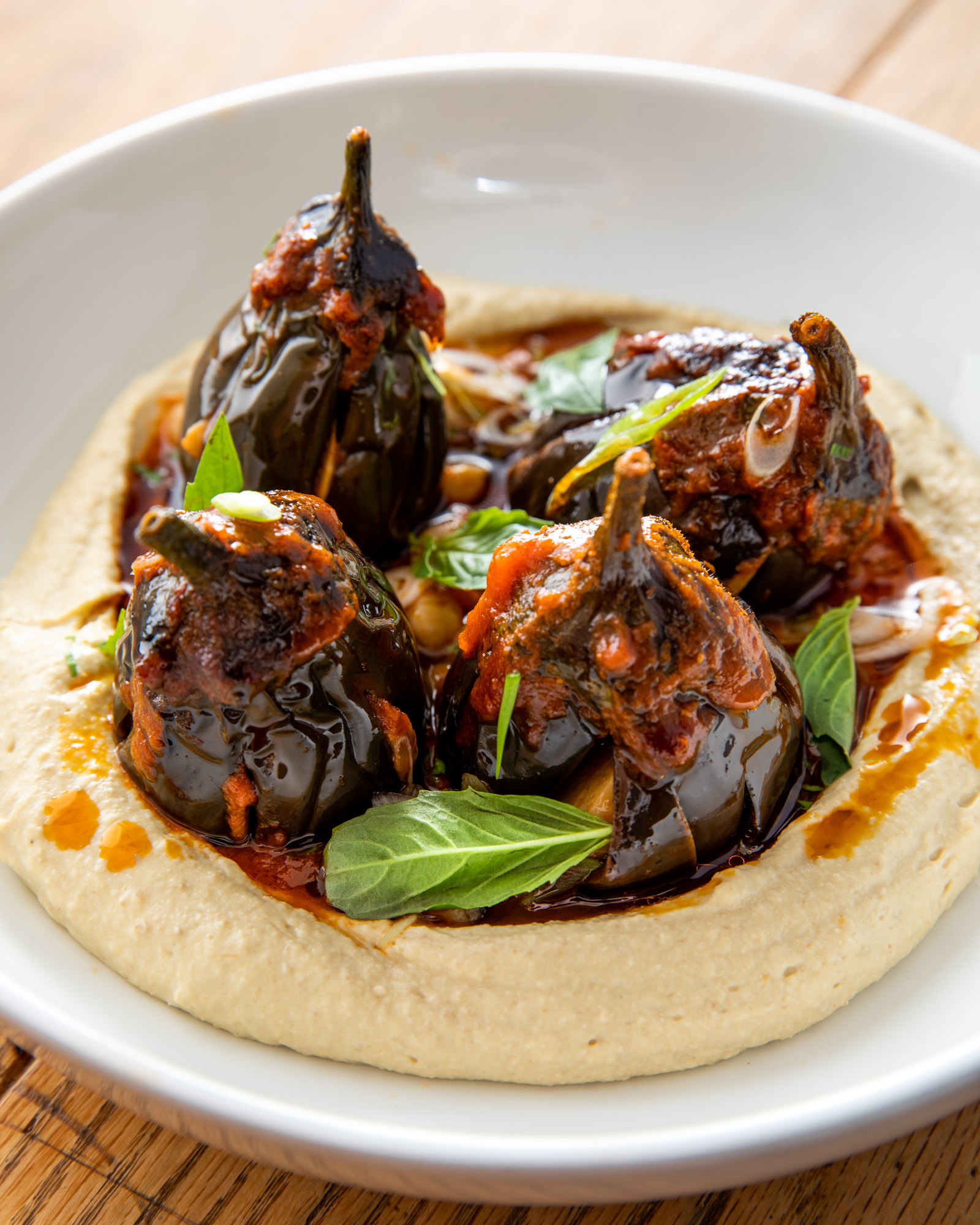 Eggplant sitting in a bed of hummus.