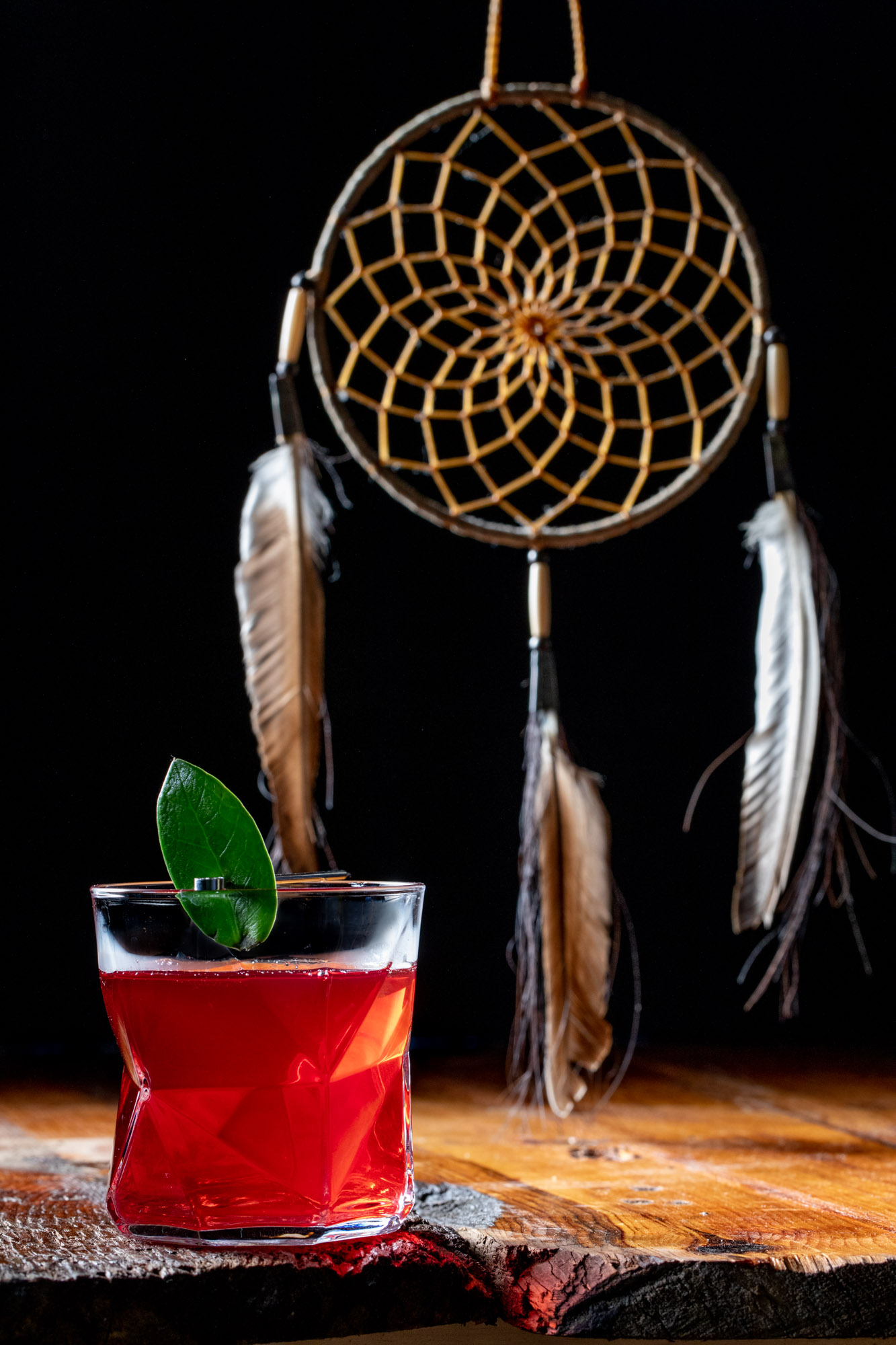 Dream catcher resting behind a glowing drink.